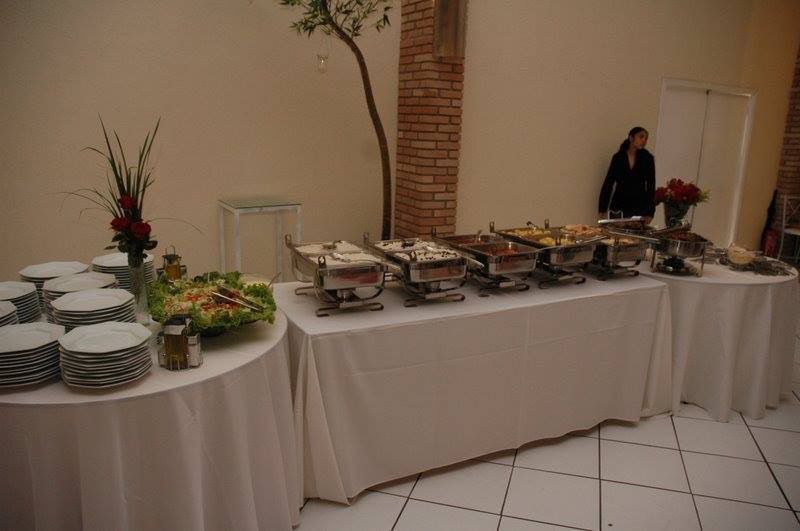 Salão de eventos com buffet completo, rechauds e decoração com árvore