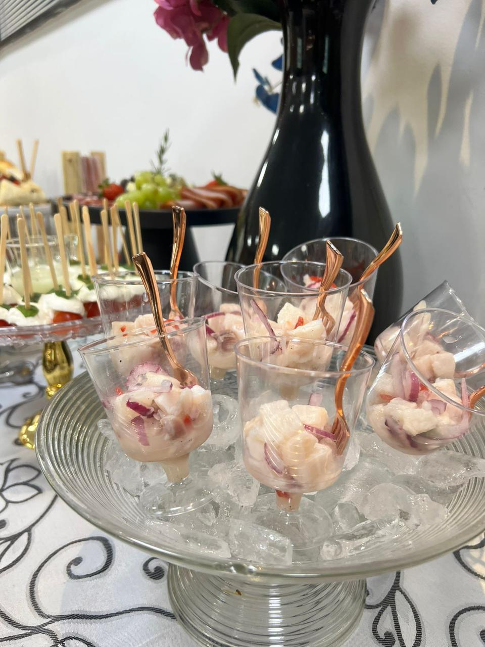 Ceviche servido em tacinhas de vidro sobre cama de gelo