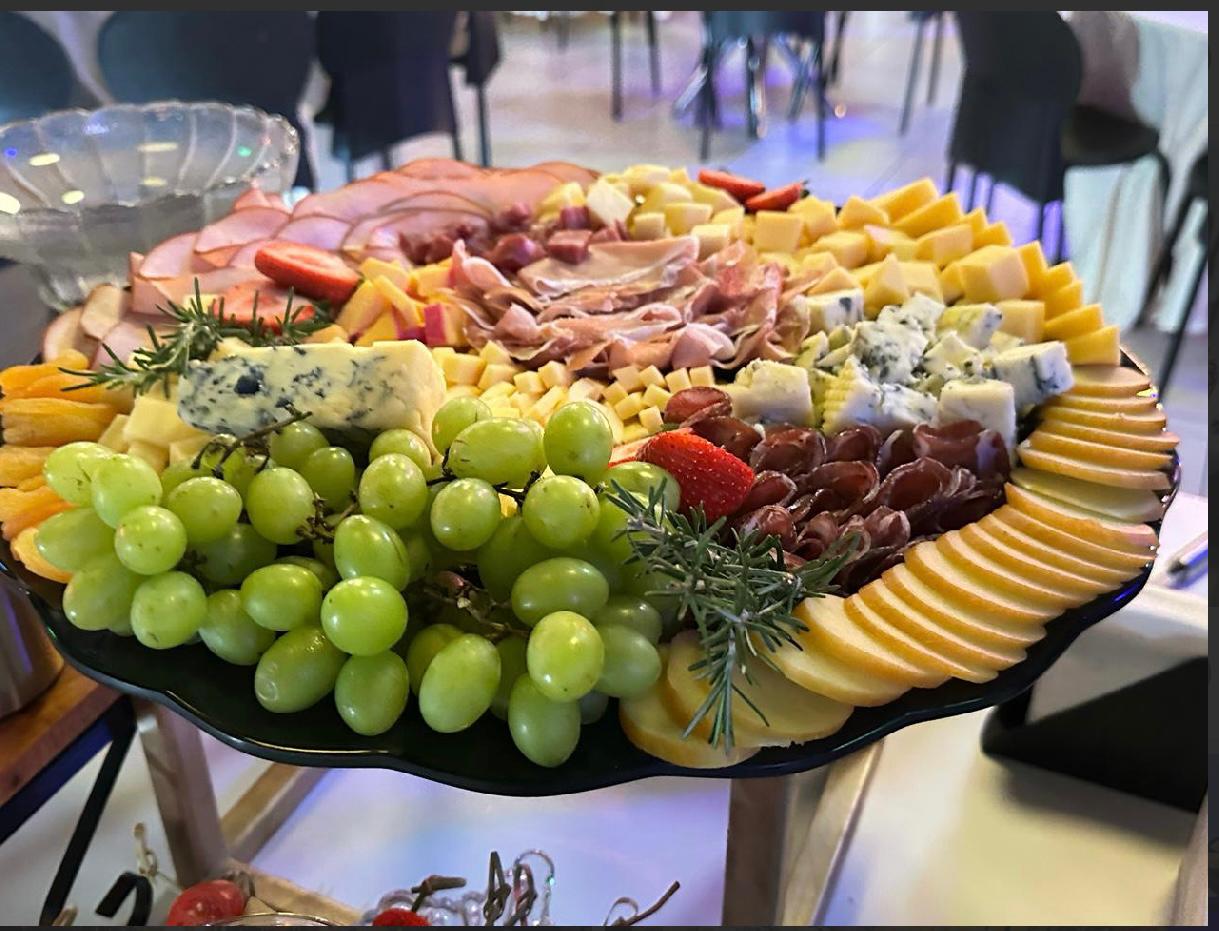 Grande tábua de frios com presunto, queijos, frutas e decoração com eucalipto