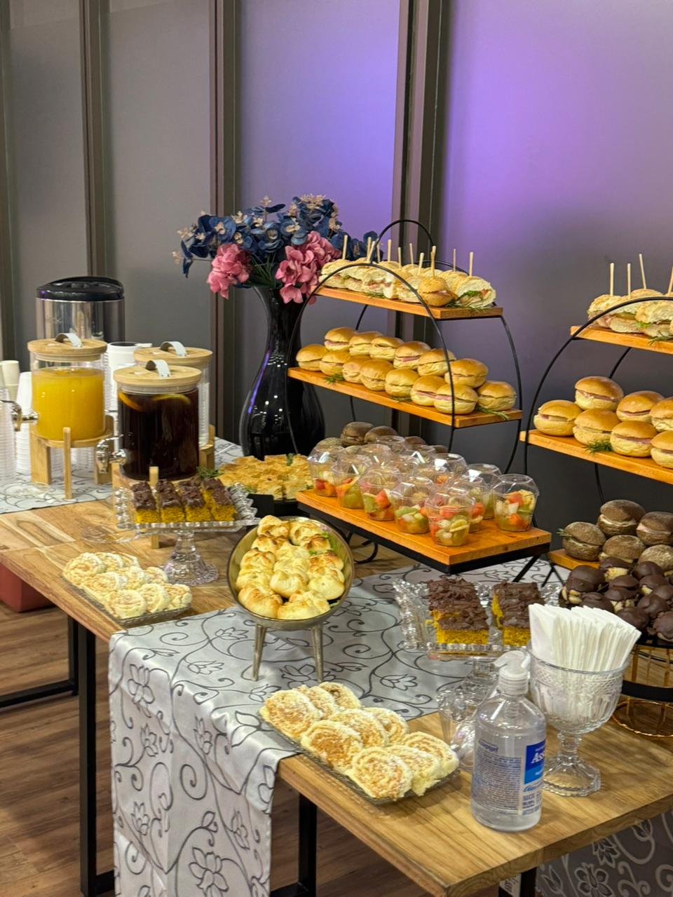 Vista geral da mesa de coffee break corporativo com iluminação roxa